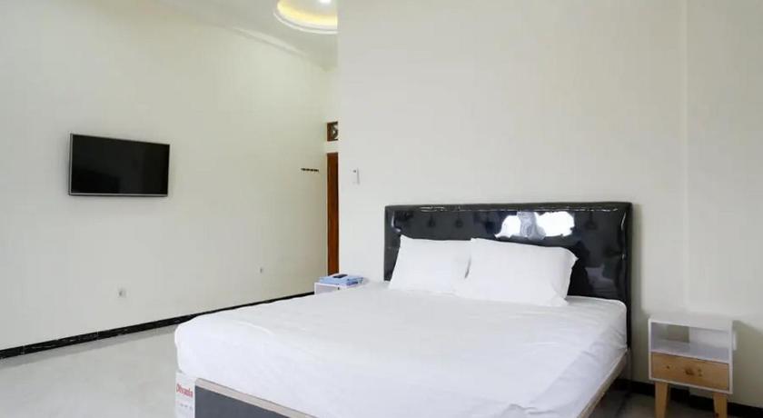 a hotel room with a white bed and white walls, Griya Mataram Kotagede RedPartner in Yogyakarta