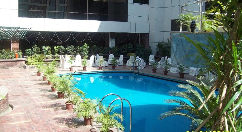 a patio with a pool and lawn chairs, Hotel Kohinoor Continental in Mumbai