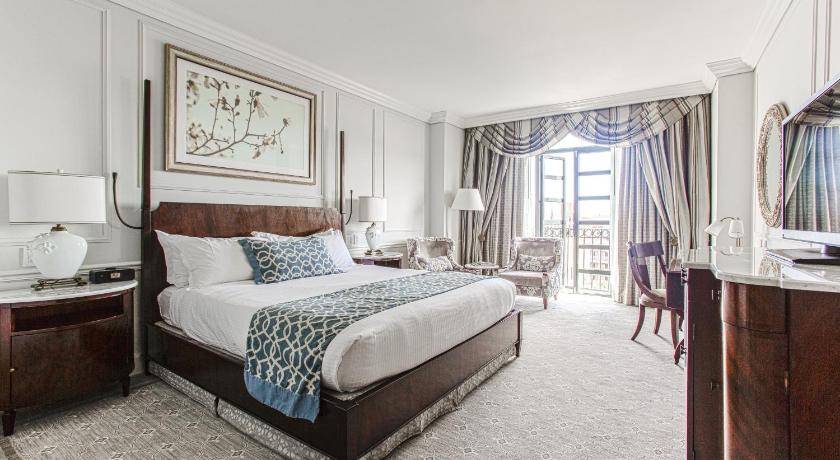 a bedroom with a large bed and a large window, The Charleston Place in Charleston (SC)