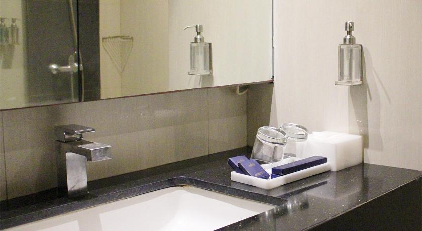 a bathroom sink sitting under a mirror next to a bath tub, Bromo Park Hotel in Probolinggo