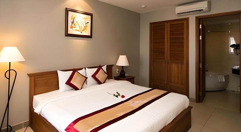 a bedroom with a bed and a dresser, White Lion Hotel in Ho Chi Minh City