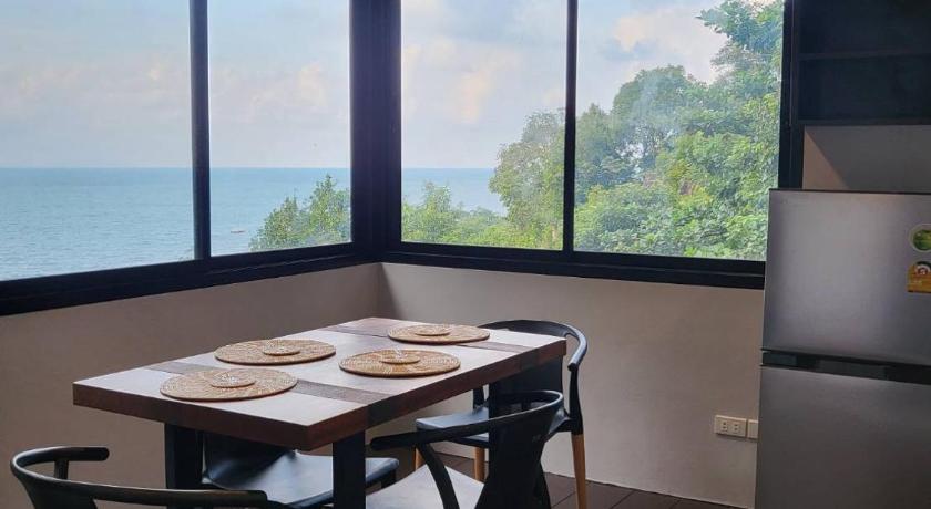 a kitchen with a table, chairs and a refrigerator, Sea Garden Resort Haad Chao Phao (SHA Plus+) in Ko Pha-ngan