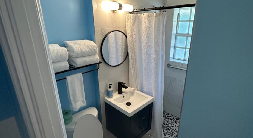 a bathroom with a toilet a sink and a mirror, Breezy Palms Resort in Islamorada (FL)