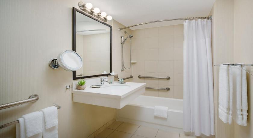 a bathroom with a shower, sink, and mirror, Crowne Plaza Phoenix Airport in Phoenix (AZ)