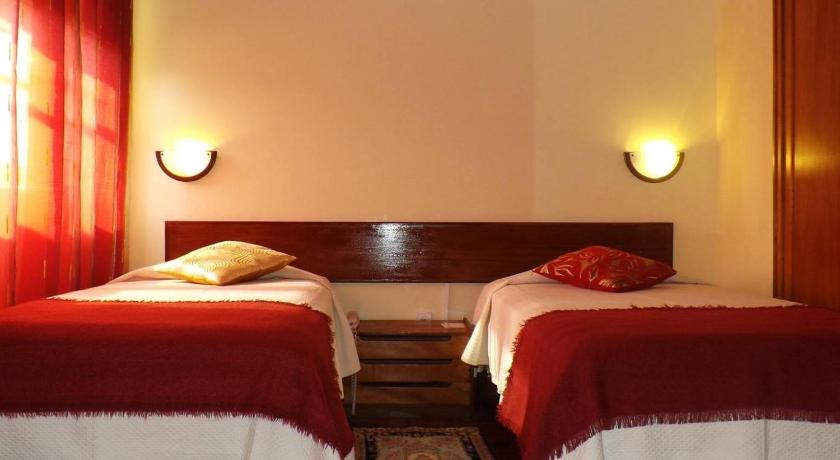 a hotel room with two beds and two lamps, Aparthotel Avenida in Mindelo
