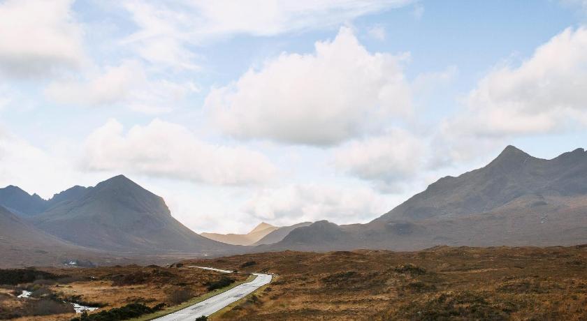 a road with mountains and a mountain range, Springburn Cottage in Isle Of Skye