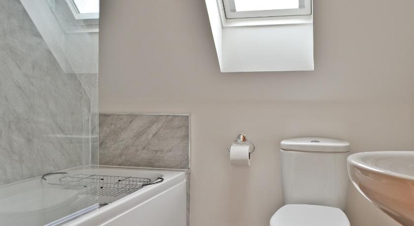 a white toilet sitting next to a bath tub in a bathroom, Springburn Cottage in Isle Of Skye