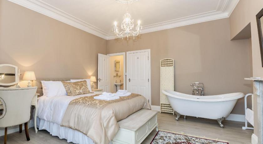 a hotel room with a bed and a bathtub, Frankland House in Whitby