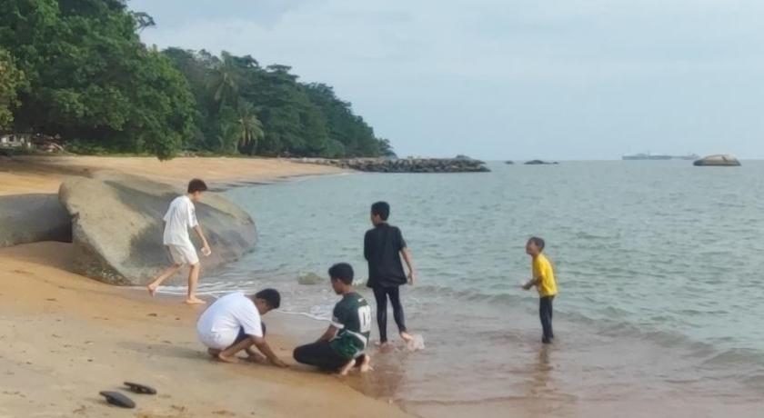 people walking on a beach with a surfboard, Mutiara Chalet in Malacca