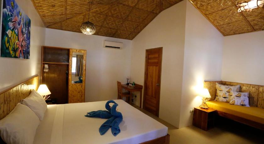 a room with a bed and a painting on the wall, Magic Oceans Dive Resort in Bohol
