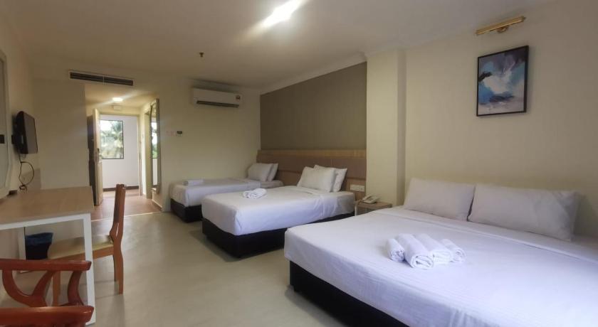 a hotel room with two beds and a television, SWISS AVENUE HOTEL in Sungai Petani