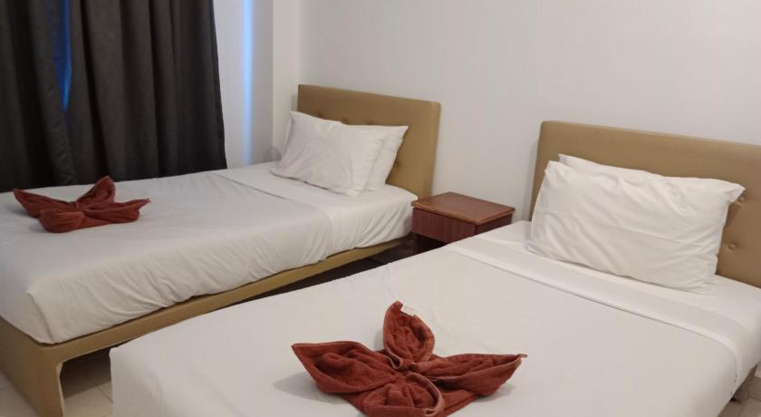 a hotel room with two beds and two lamps, Sumai Hotel Apartment in Kuala Terengganu