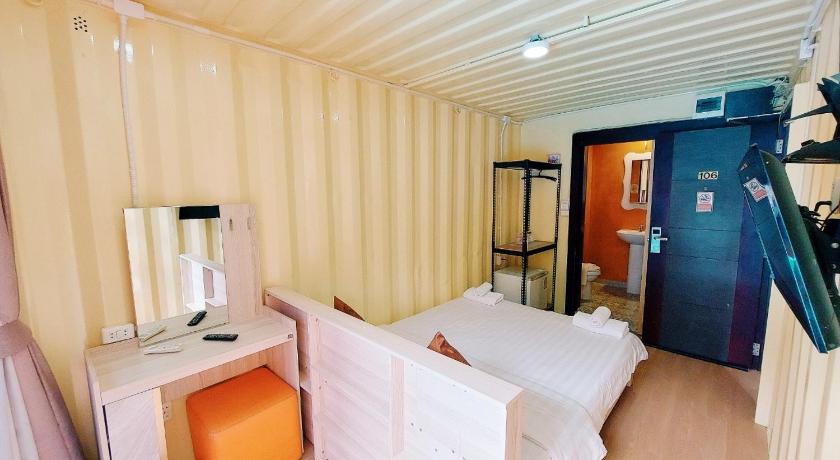 a room with a bed, a chair, and a door, Retro Box Hotel in Chumphon