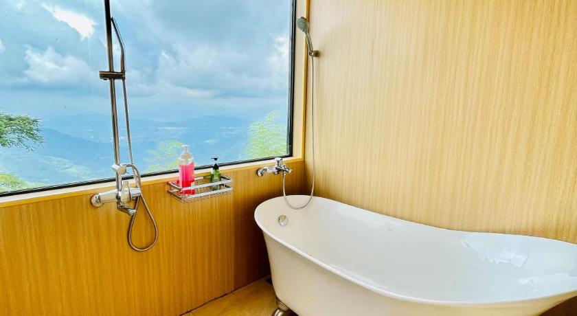 a bath tub sitting in a bathroom next to a window, Shen Shan Lin Nai B&B in Nantou