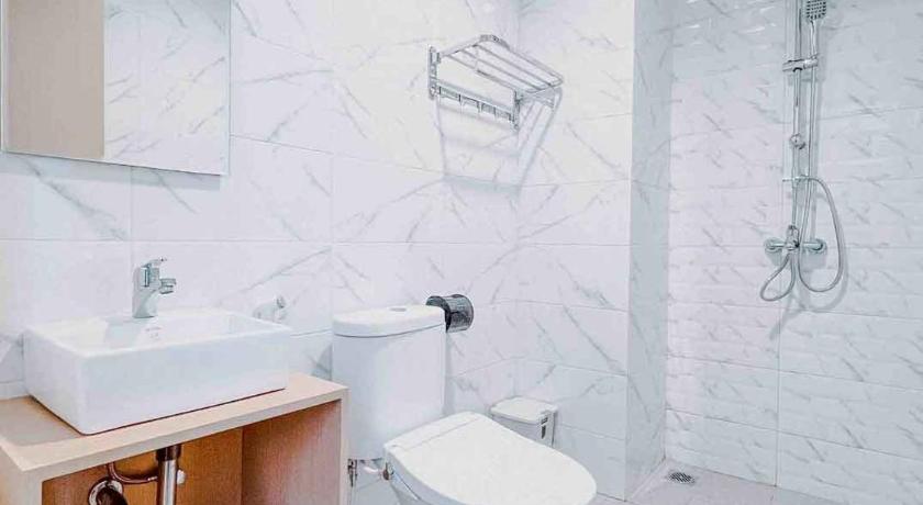 a white toilet sitting in a bathroom next to a sink, Ariandri Resort Puncak in Puncak