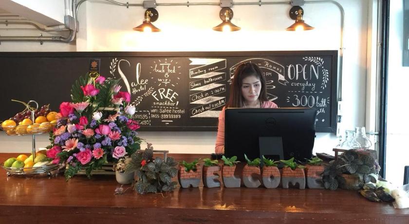 a woman sitting at a table with a laptop, Salee Hostel in Chiang Mai