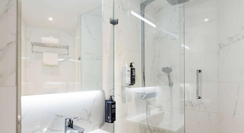a bathroom with a sink, mirror, and bath tub, Ibis Styles Amsterdam CS Hotel in Amsterdam