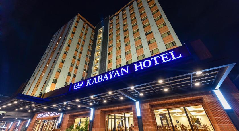a large building with a clock on the front of it, Kabayan Hotel in Manila