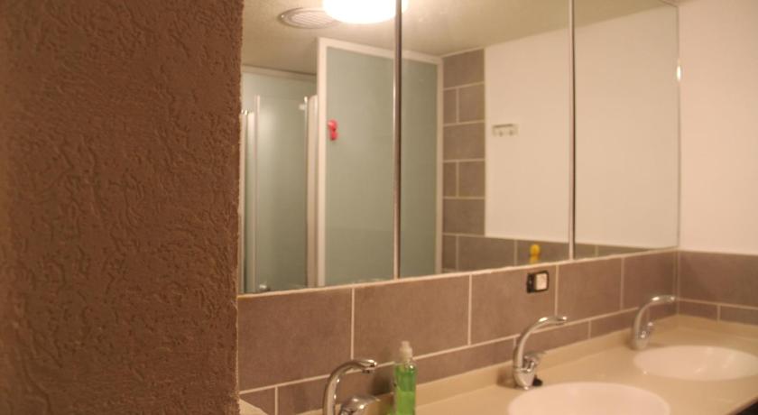 a bathroom with a sink and a mirror, Al Yakhour Hostel in Haifa