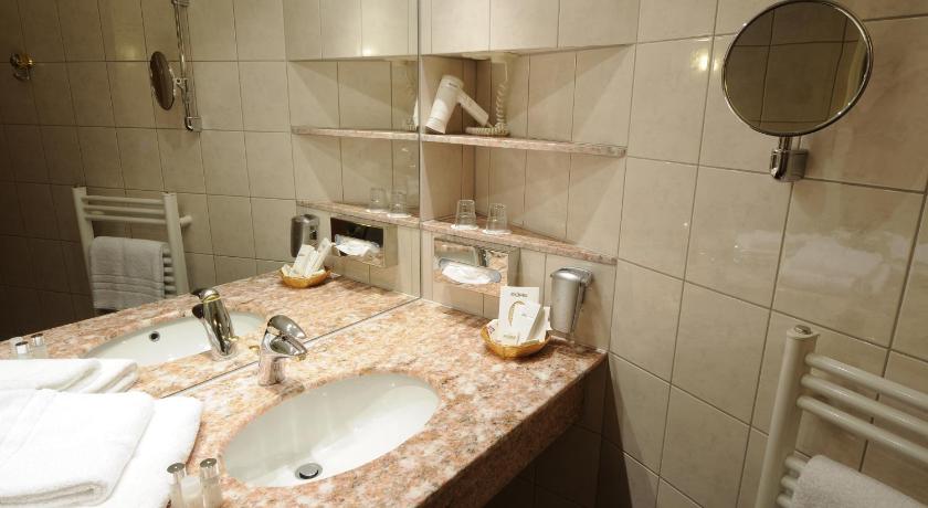 a bathroom with a sink and a mirror, AXXON Hotel in Brandenburg an der Havel