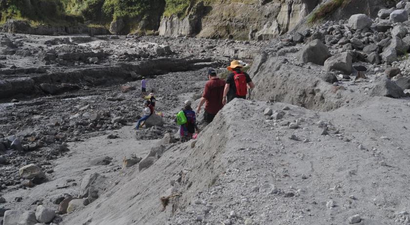 people are walking along a rocky shoreline, Allan Bognots Pinatubo Guesthouse in Capas