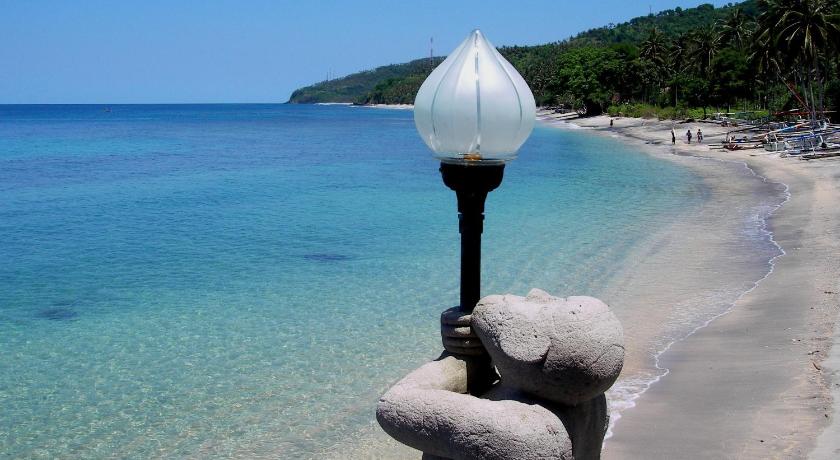a white and blue fire hydrant on a beach, Puri Mas Boutique Resorts & Spa in Lombok