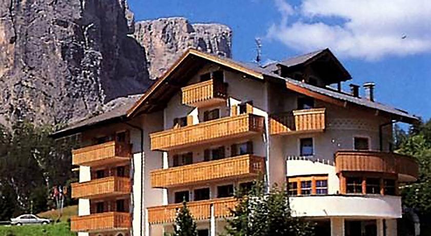 a large stone building with a view of a mountain range, Pensione Sellablick in Corvara In Badia