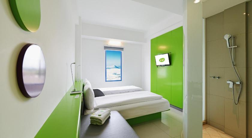 a bedroom with a bed and a mirror, POP! Hotel Malioboro in Yogyakarta