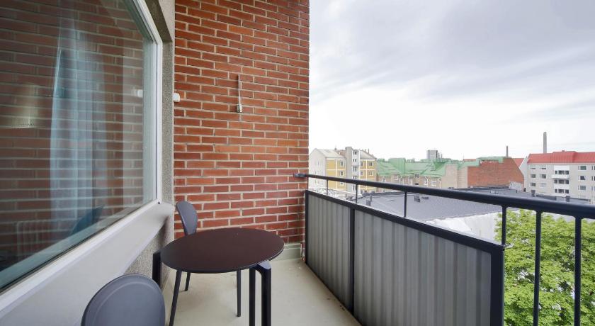a chair sitting in front of a window next to a fence, Forenom Serviced Apartments Helsinki Lapinlahdenkatu in Helsinki