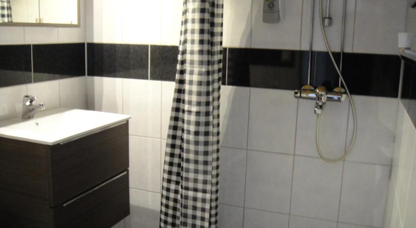 a bathroom with a shower, sink, and toilet, Cafe Asema B&B in Kuopio