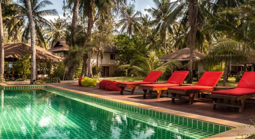 a pool with chairs, tables, and umbrellas in it, Baan Manali Resort in Ko Pha-ngan