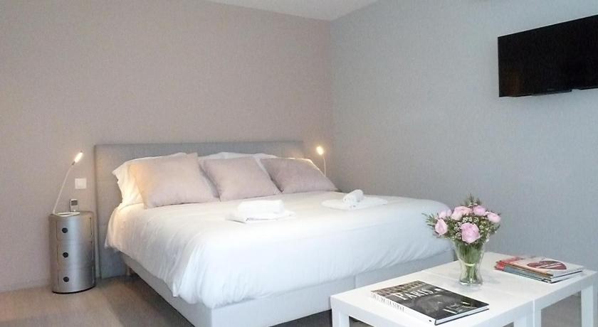 a bedroom with a white bedspread and white pillows, Studios Albri in Fontenay-sous-Bois