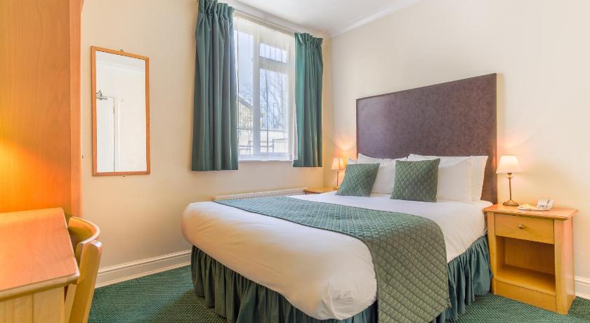 a bedroom with a large bed and a large window, London Town Hotel in London