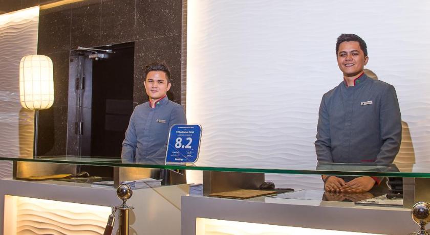 a woman and a man standing in front of a counter, Y2 Residence Hotel Managed By HII in Manila