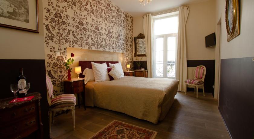 a bedroom with a large bed and a large window, Au Coeur de Bordeaux - B&B et Cave a vin in Bordeaux