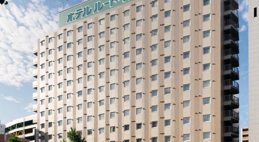 a large building with a large building behind it, Hotel Route Inn Nagoya Imaike Ekimae in Nagoya