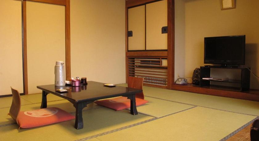 a living room with a table and chairs, Sakaeya Hotel in Yamagata