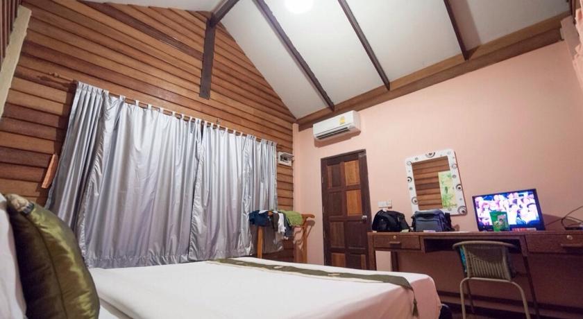 a hotel room with a bed and a tv, Hallo Villa at Khanom in Nakhon Si Thammarat