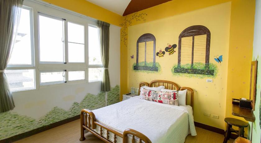 a bedroom with a bed and a painting on the wall, Kenting Bonjour Resort in Kenting