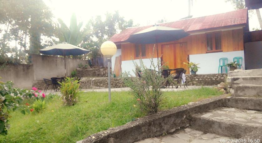 a cow standing next to a patio with a house, Ue datu Cottages in Tentena