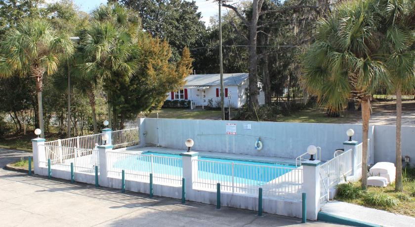a swimming pool with a pool table and chairs, Travelers Inn Gainesville in Gainesville (FL)