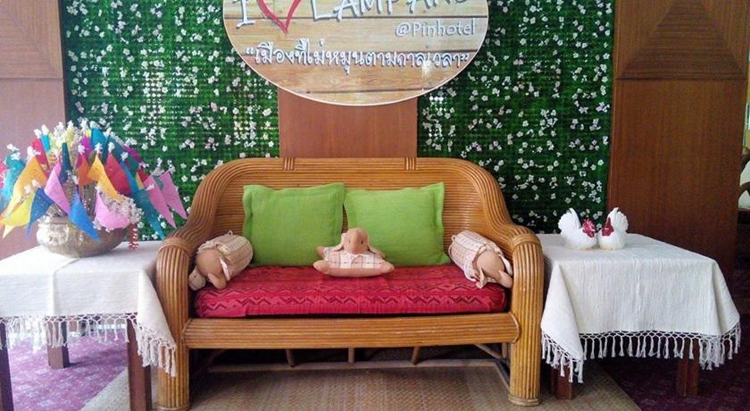 a small doll sitting on top of a bed in a room, Pin Hotel in Lampang