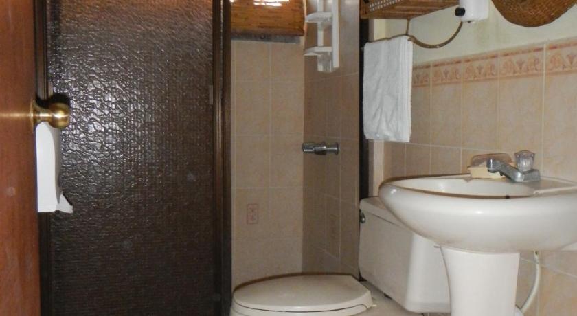 a bathroom with a toilet, sink and mirror, Punta Roca Surf Resort in La Libertad