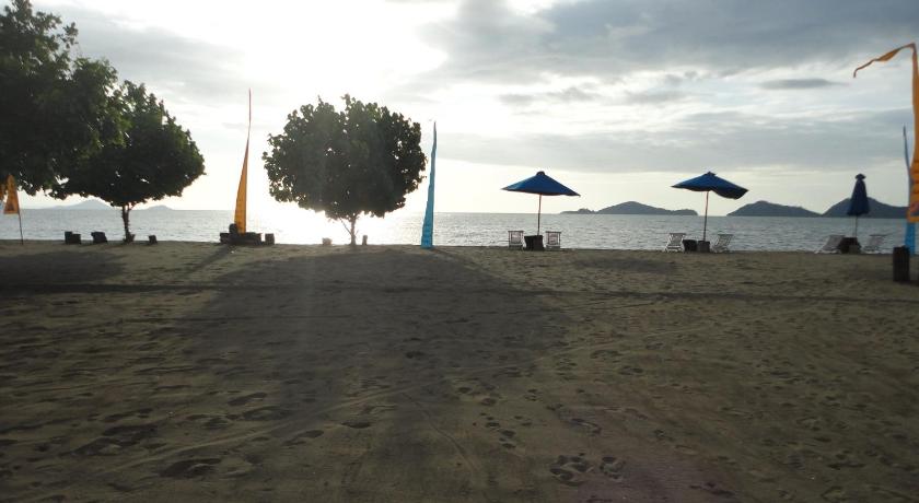 a beach with umbrellas and people on it, Puri Sari Beach Hotel in Labuan Bajo