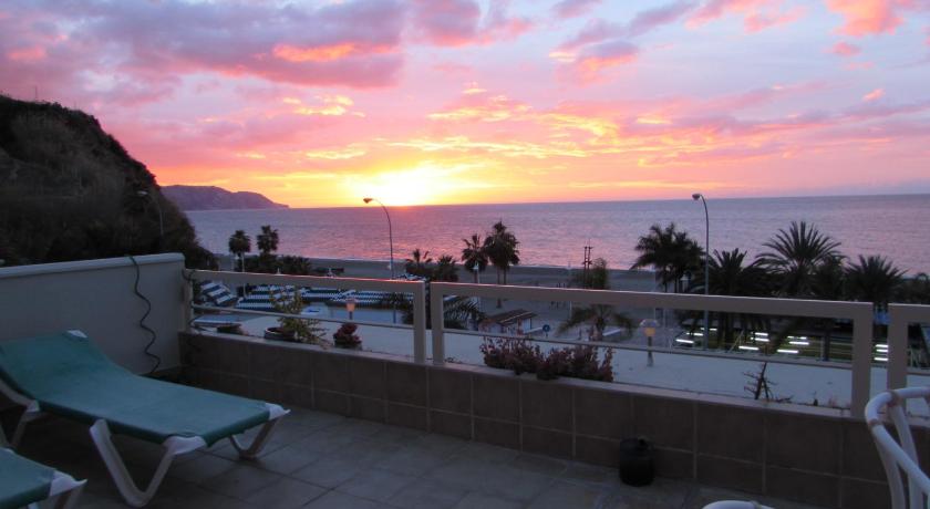 a beach scene with a balcony overlooking the ocean, Home4Holidays in Nerja