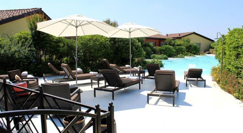 a patio area with chairs, tables and umbrellas, Joia Hotel & Luxury Apartments in Brusaporto