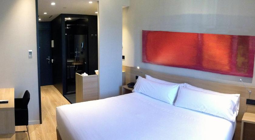 a hotel room with a bed, desk and a television, Hotel Ambit Barcelona in Barcelona