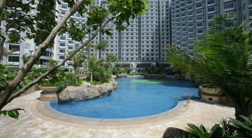 a large swimming pool with a large stone building, Kowloon Harbourfront Hotel in Hong Kong