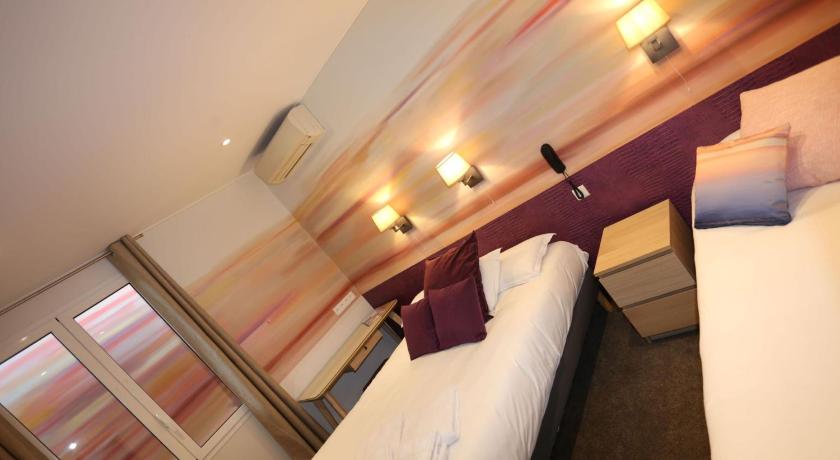 Image of Triple Room with window overlooking a painted wall 4