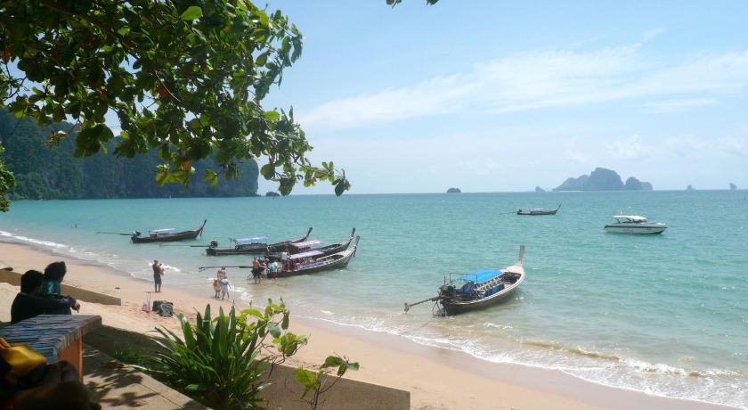 boats are docked in the water near the beach, The Capuchin Hotel in Krabi